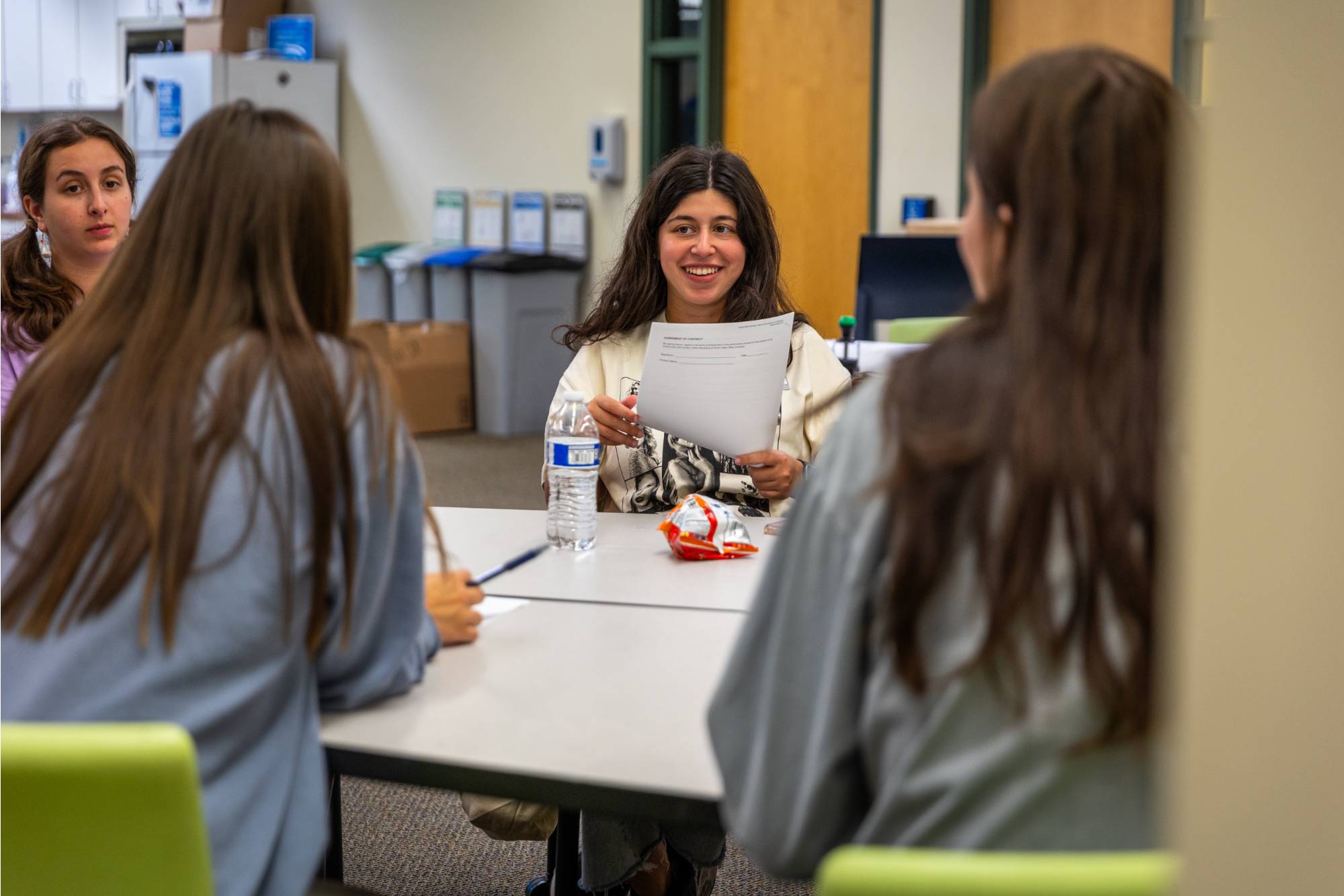 Students sitting at a table and reading the document